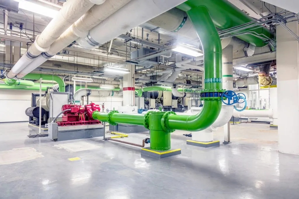 Central plant room with large glycol cooling pipes and pumps